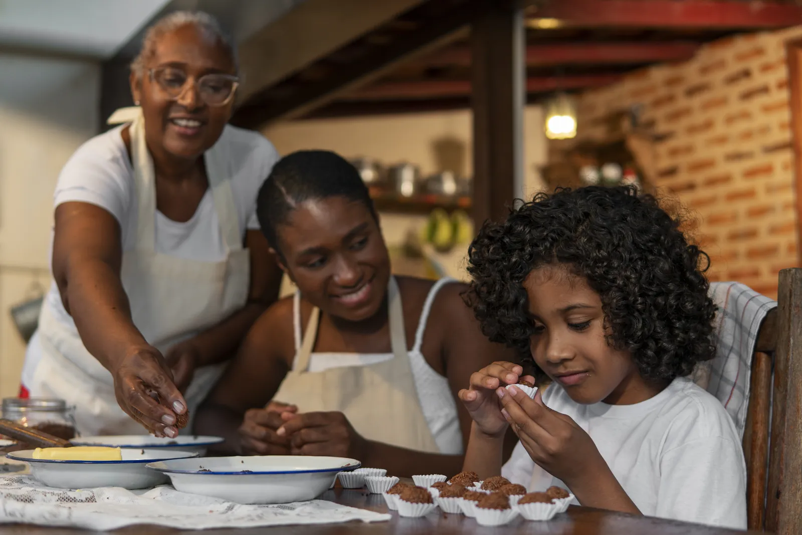 Avó, filha e neta fazendo brigadeiro juntas na cozinha